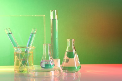 Laboratory analysis. Different glassware on table against color background, space for text