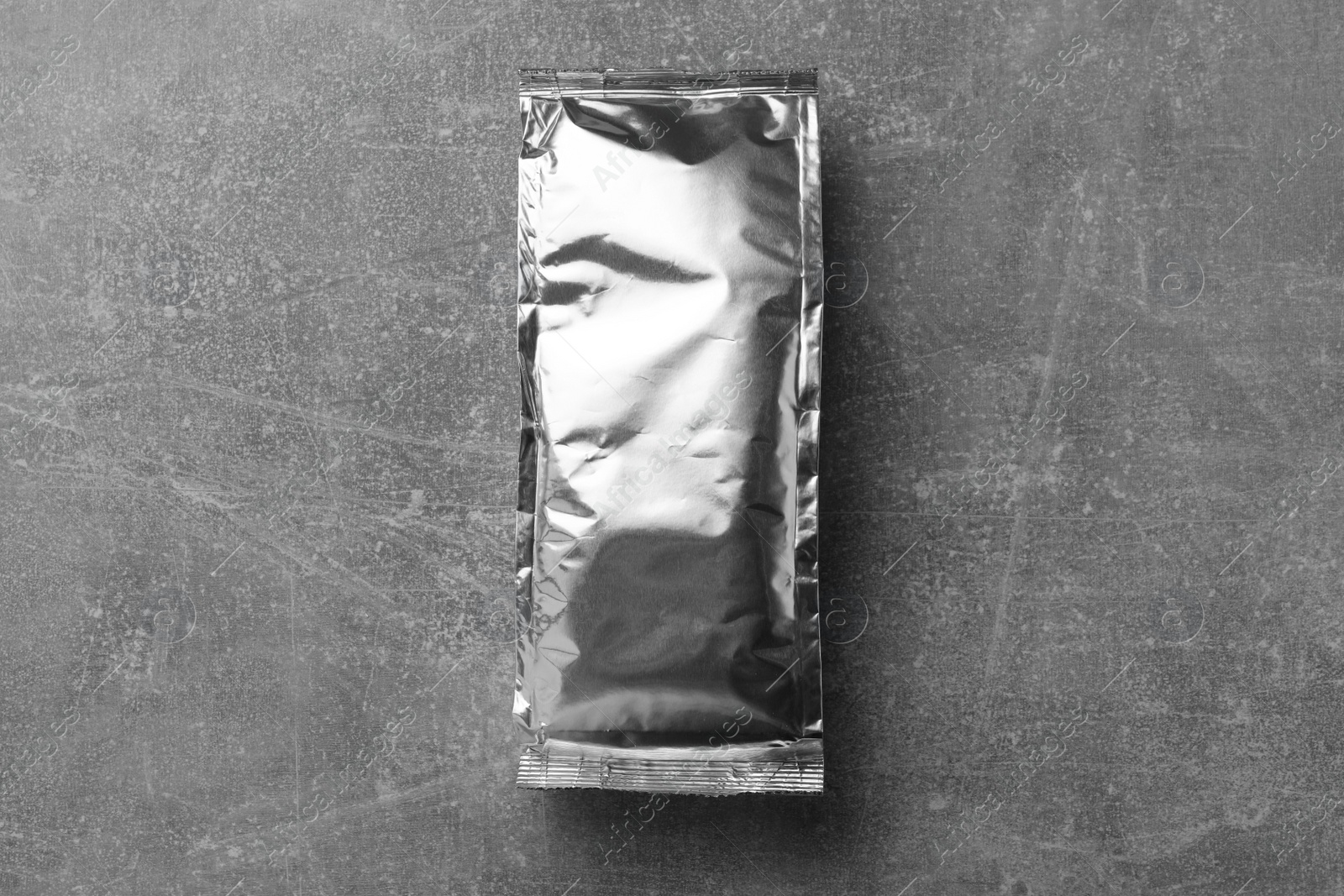 Photo of Blank foil package on grey table, top view