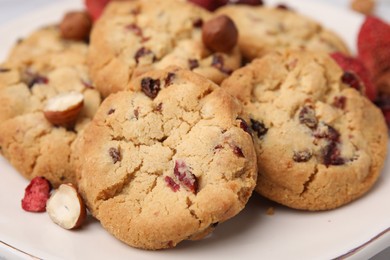 Photo of Cookies with freeze dried fruits and nuts on white plate, closeup