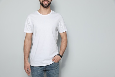 Photo of Young man in t-shirt on light background, closeup. Mock up for design