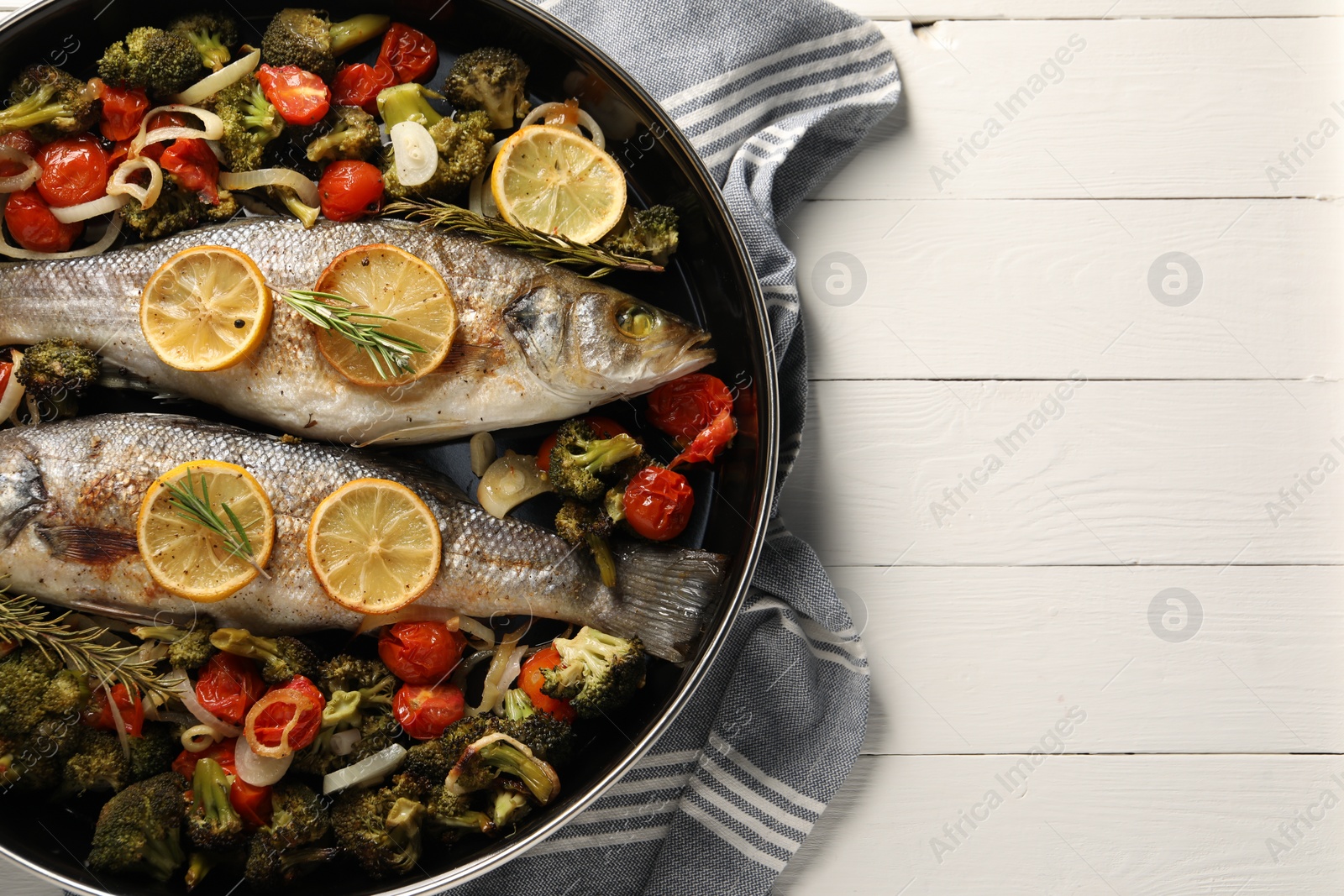 Photo of Baked fish with vegetables, rosemary and lemon on white wooden table, top view. Space for text