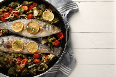 Photo of Baked fish with vegetables, rosemary and lemon on white wooden table, top view. Space for text