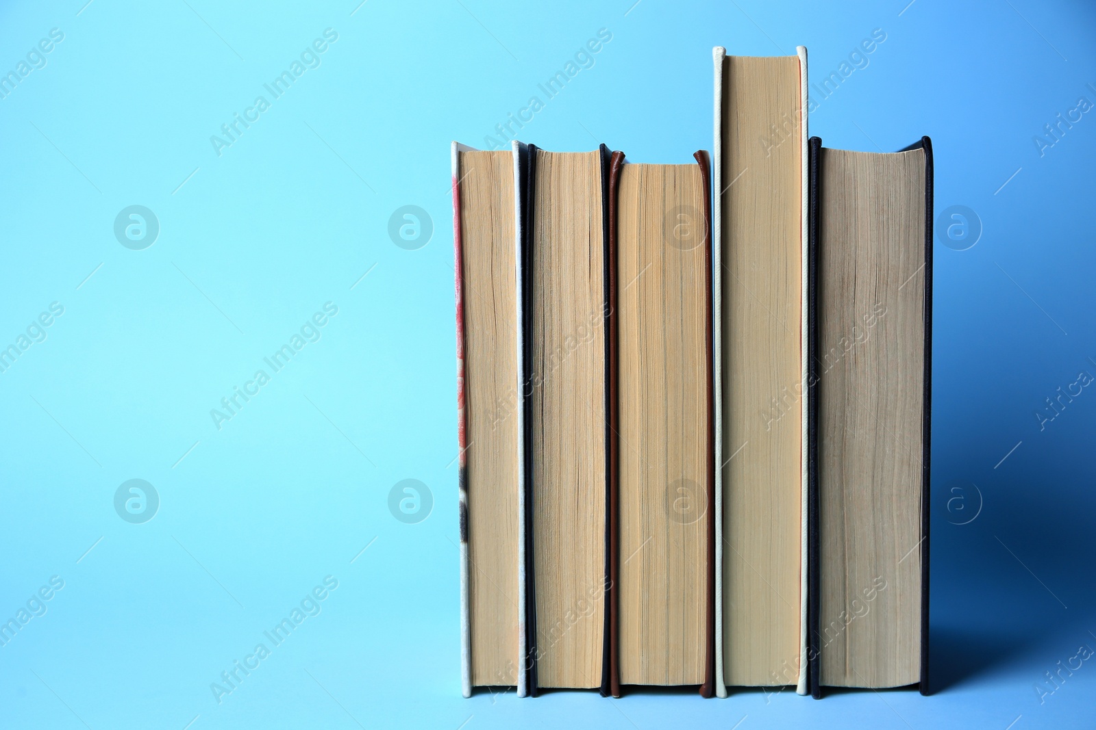 Photo of Collection of books on light blue background, space for text