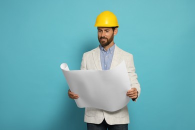 Photo of Professional engineer in hard hat with draft on light blue background