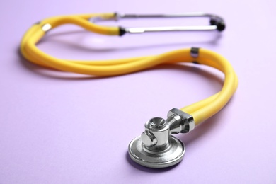 Photo of Stethoscope with space for text on color background, closeup. Medical tool