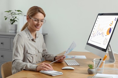 Professional accountant working at wooden desk in office