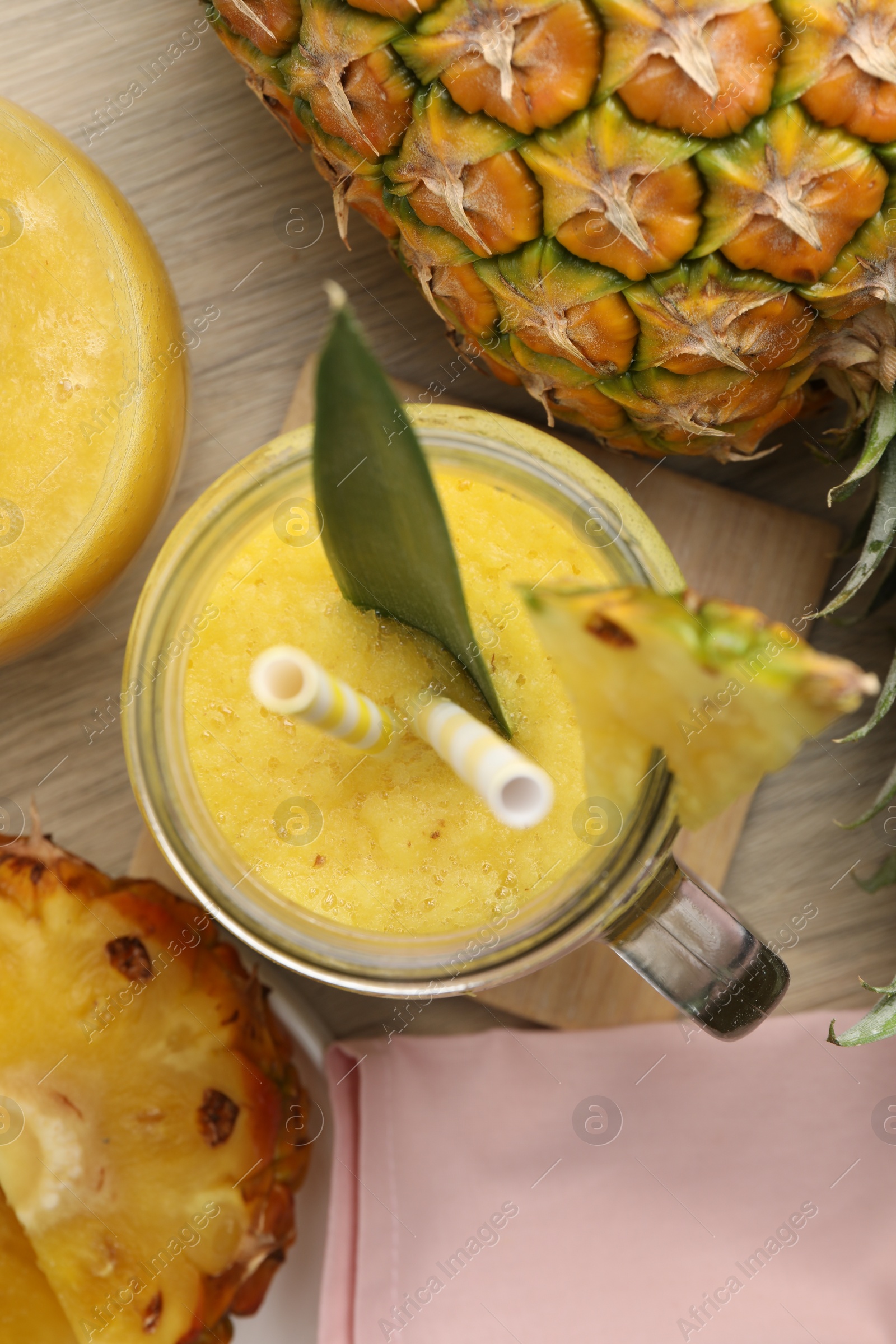 Photo of Tasty pineapple smoothie and fruit on wooden table, flat lay