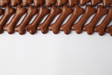 Bone shaped dog cookies on white background, flat lay. Space for text