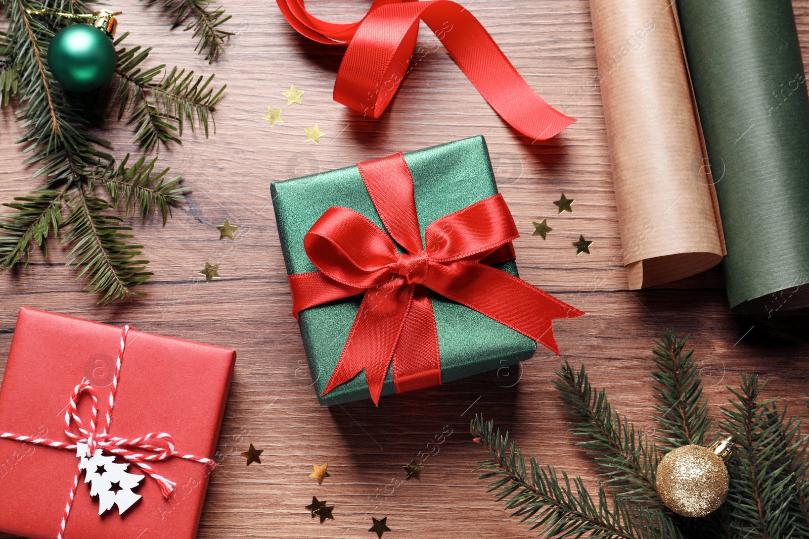 Photo of Flat lay composition with beautiful Christmas gift boxes and wrapping paper on wooden table