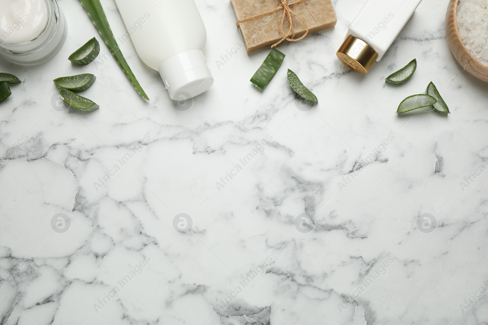 Photo of Flat lay composition with aloe vera and cosmetic products on white marble background. Space for text