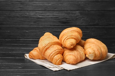 Photo of Tasty croissants on wooden table