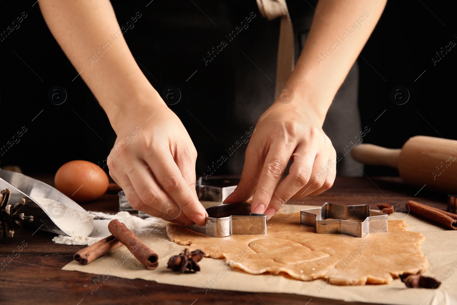 Photo of Woman making Christmas cookies at wooden table, closeup