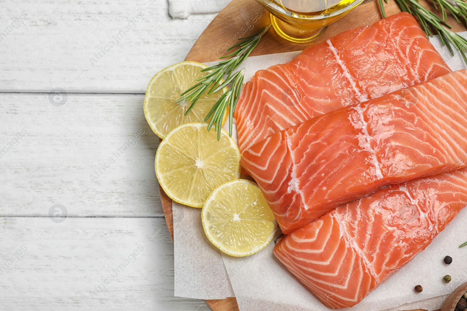 Photo of Top view of fresh raw salmon and products on white wooden table. Fish delicacy