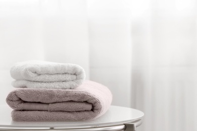 Stack of clean towels on table indoors