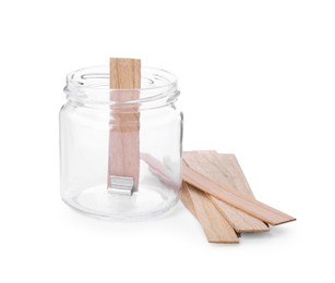 Photo of Glass jar and wooden wicks on white background. Making homemade candle