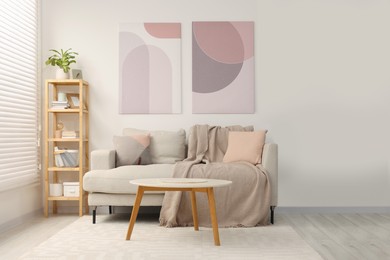 Photo of Stylish living room interior with sofa, coffee table and wooden shelf