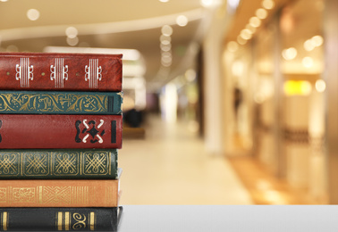 Image of Collection of different books on table against blurred background, space for text