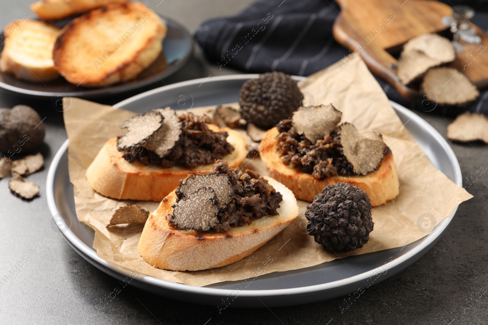 Photo of Delicious bruschettas with truffle sauce on grey table