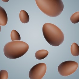 Image of Many chocolate eggs falling on grey background