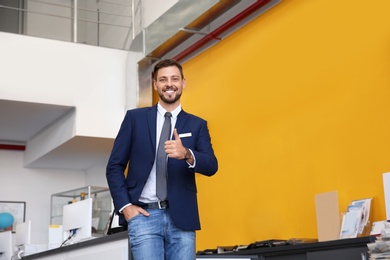 Photo of Salesman standing in modern auto dealership. Buying new car