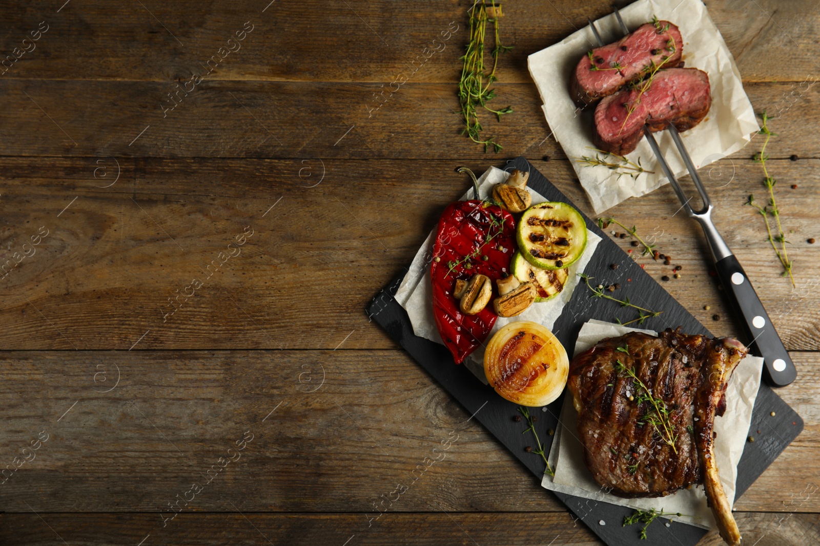 Photo of Flat lay composition with grilled meat on wooden table. Space for text