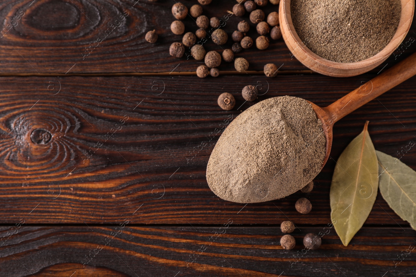 Photo of Flat lay composition with black pepper on wooden table, space for text