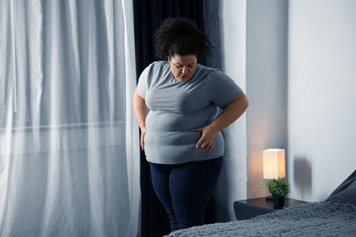 Overweight woman suffering from depression at home