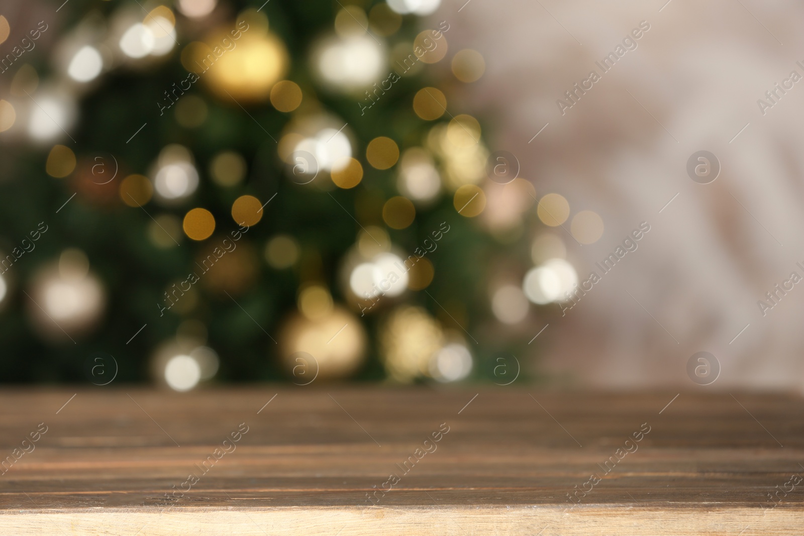 Photo of Empty wooden table and blurred fir tree with Christmas lights on background, bokeh effect. Space for design