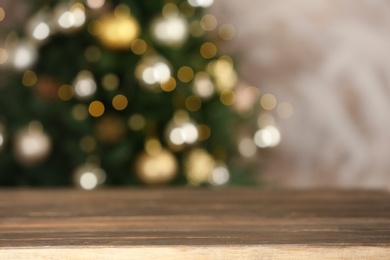 Photo of Empty wooden table and blurred fir tree with Christmas lights on background, bokeh effect. Space for design