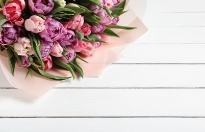 Photo of Bouquet of beautiful tulips on white wooden table, closeup. Space for text