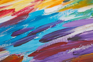 Photo of Beautiful strokes of colorful oil paints on white canvas as background, closeup