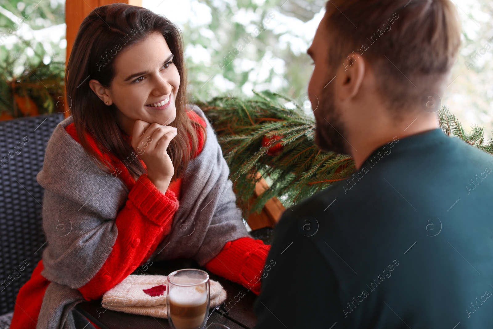 Photo of Happy couple at table in cafe. Winter vacation