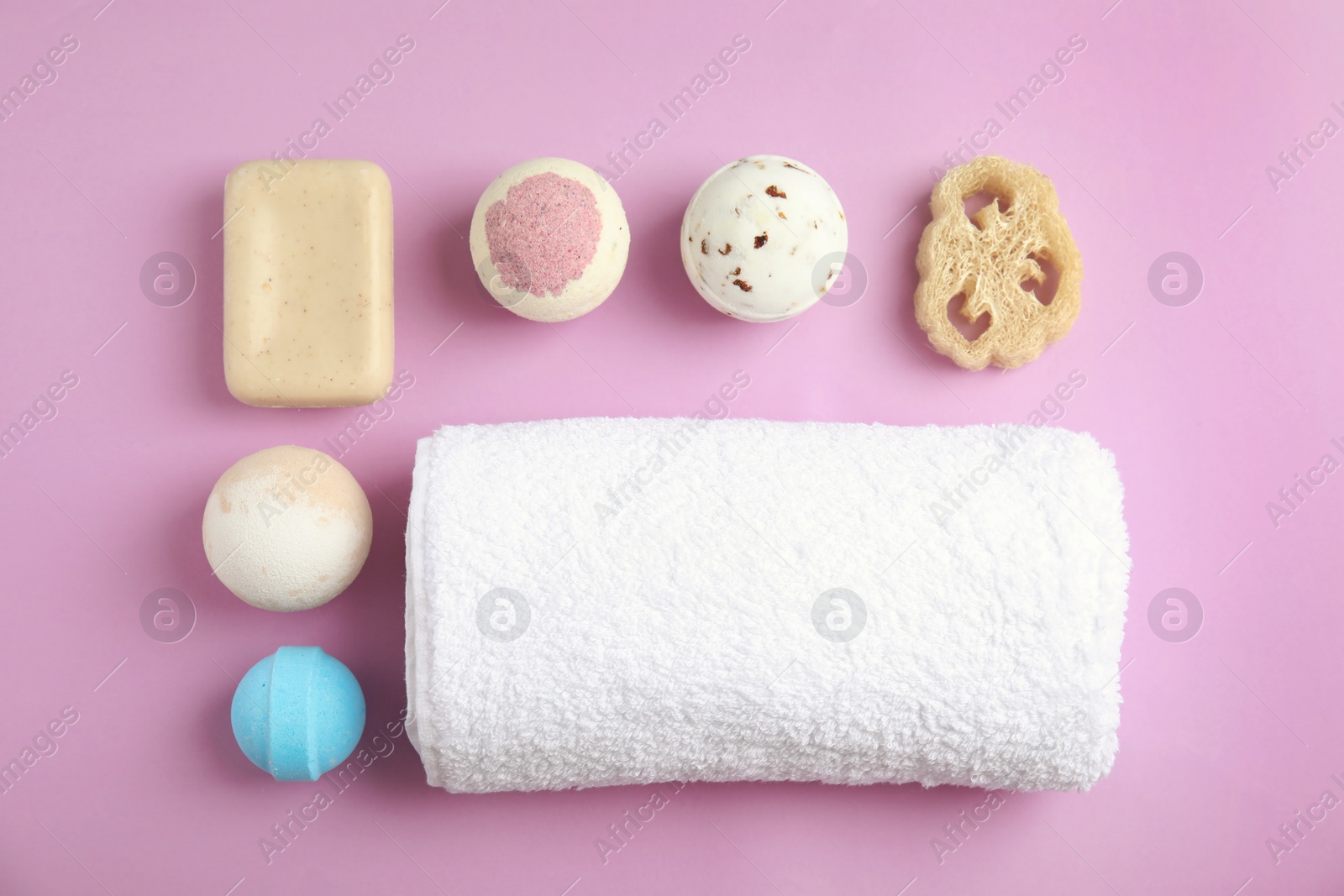 Photo of Flat lay composition with bath bombs, soap and towel on color background