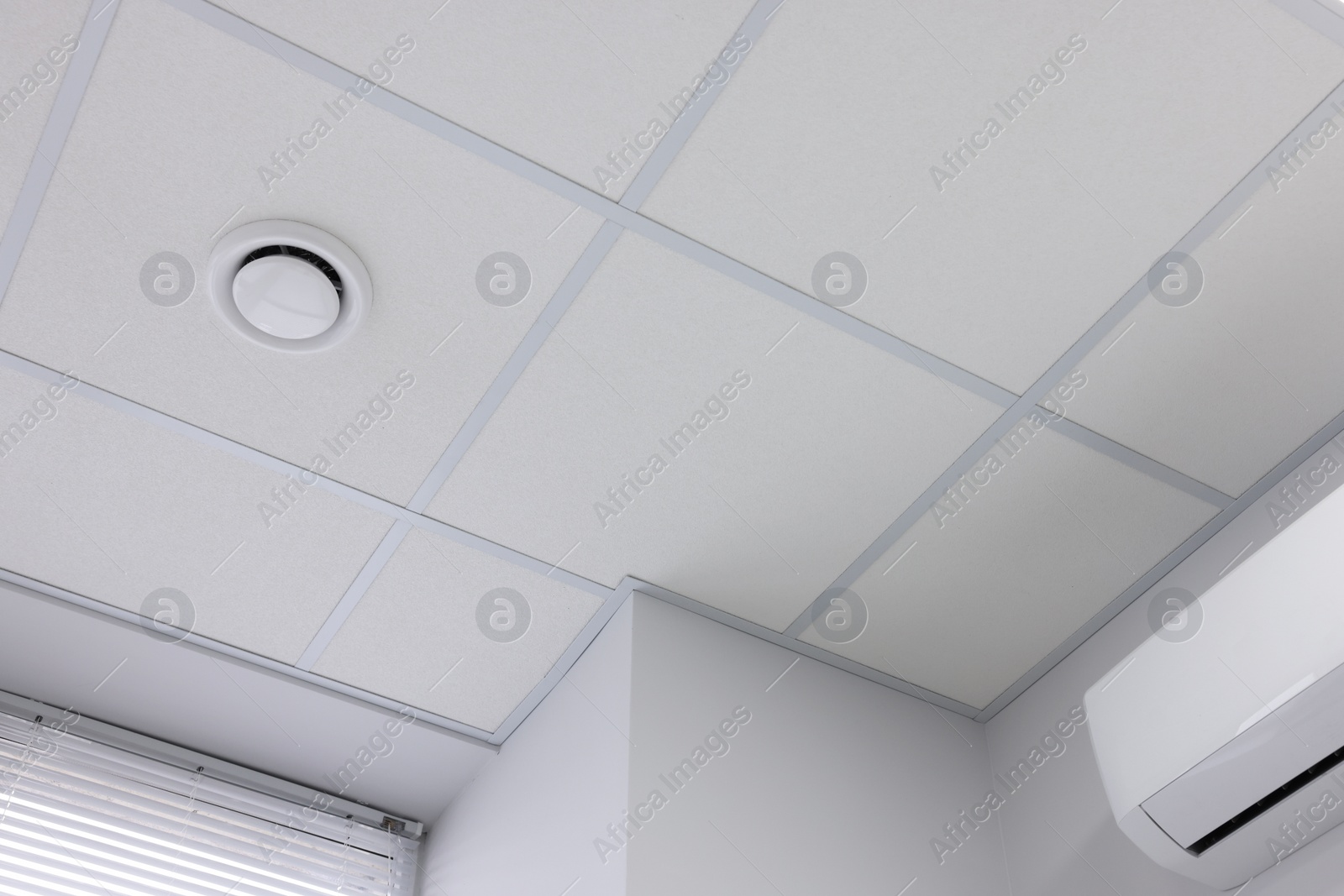 Photo of White ceiling with PVC tiles indoors, low angle view