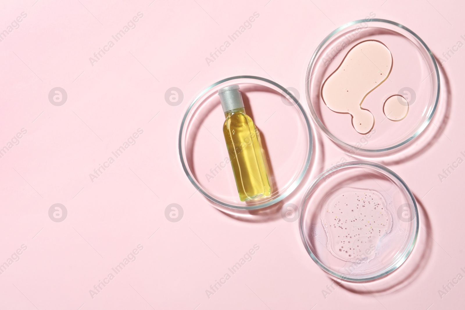 Photo of Many Petri dishes and cosmetic products on pink background, flat lay. Space for text