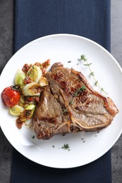 Photo of Delicious fried beef meat and vegetables on grey table, top view