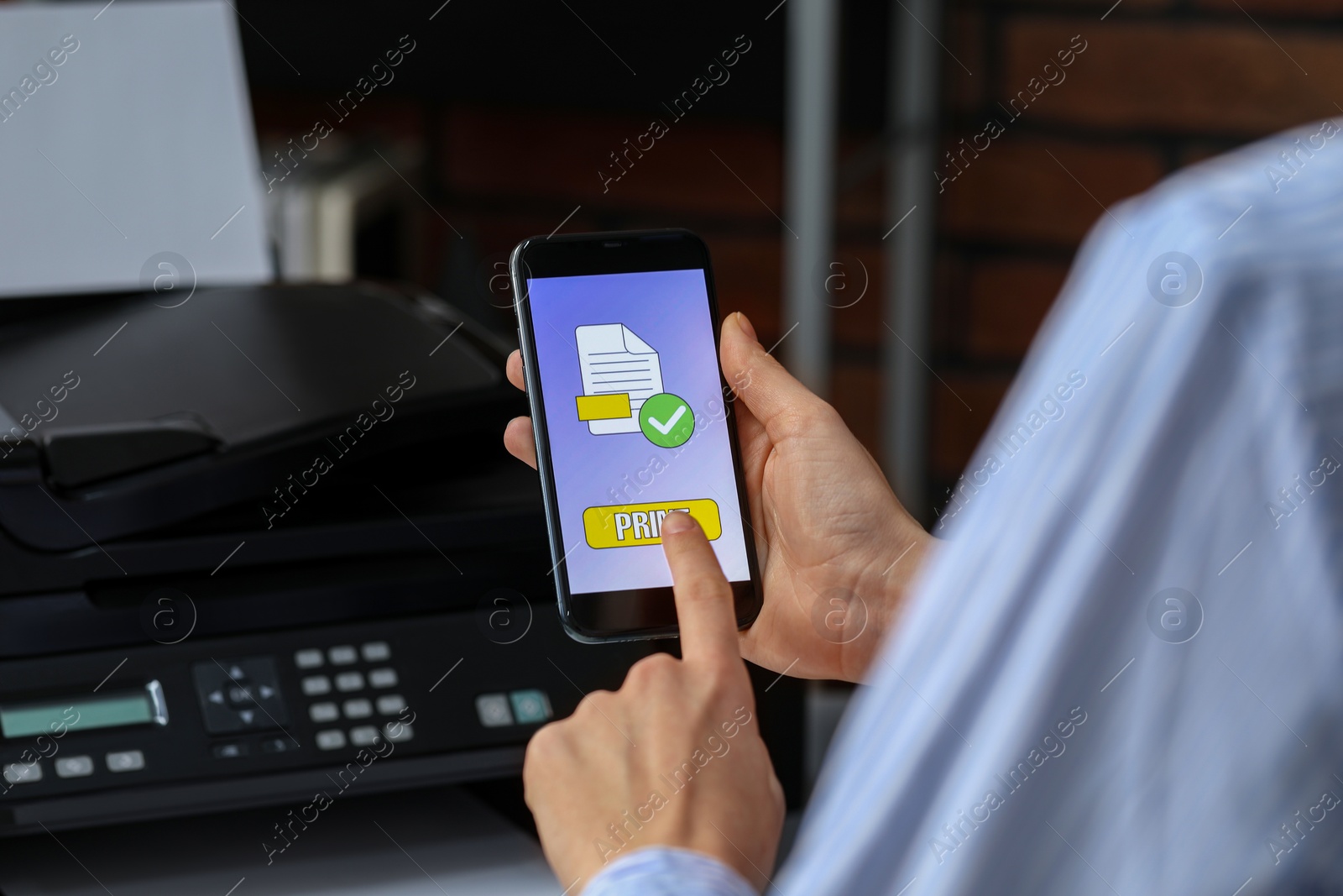 Photo of Man using printer management application on mobile phone indoors, closeup. Image on device screen.