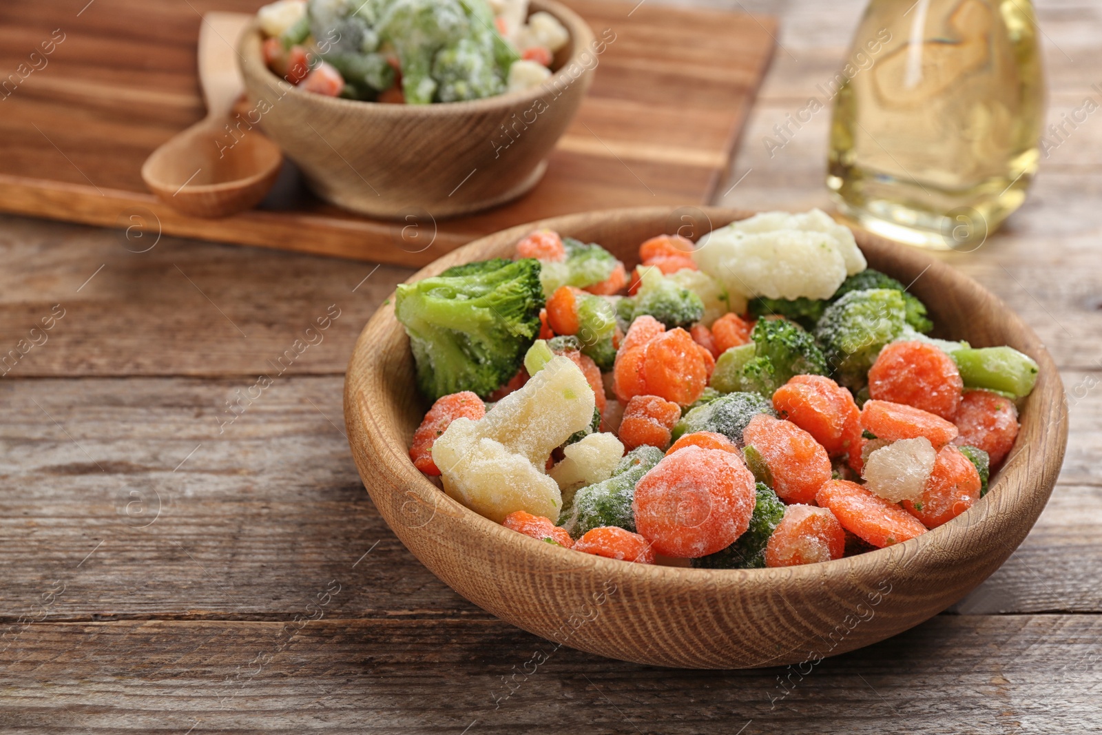 Photo of Tasty frozen vegetable mix on wooden table, closeup