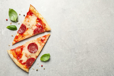 Photo of Slices of hot delicious pepperoni pizza on light grey table, flat lay. Space for text