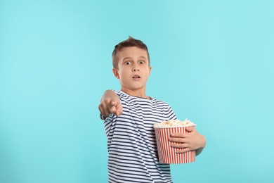 Photo of Emotional boy with popcorn during cinema show on color background