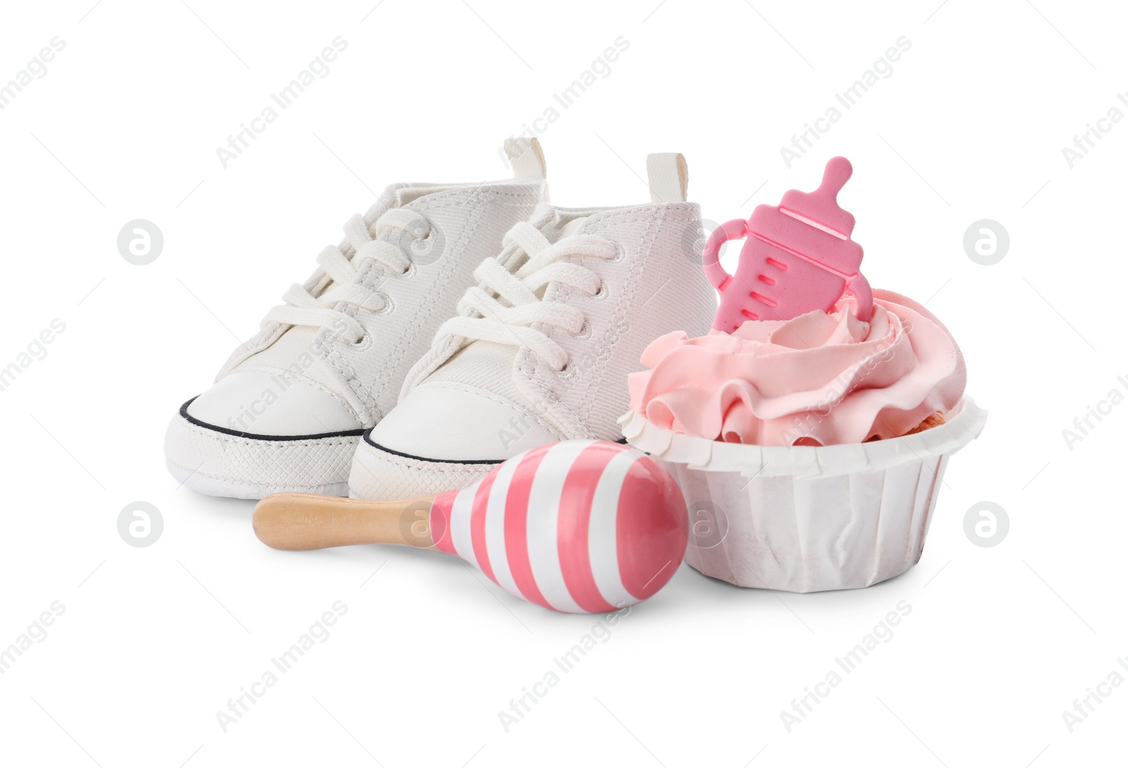 Photo of Baby shower cupcake with pink cream near shoes and toy on white background