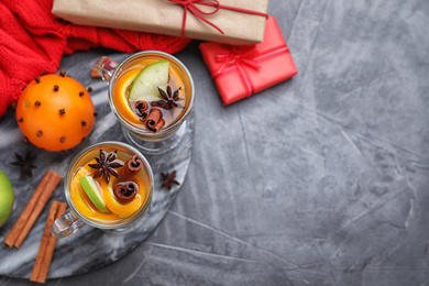 Photo of Aromatic white mulled wine served on grey table, flat lay. Space for text