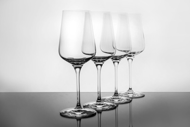 Photo of Row of empty wine glasses on white background