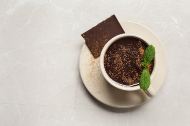 Cup of delicious hot chocolate with fresh mint on grey table, top view. Space for text