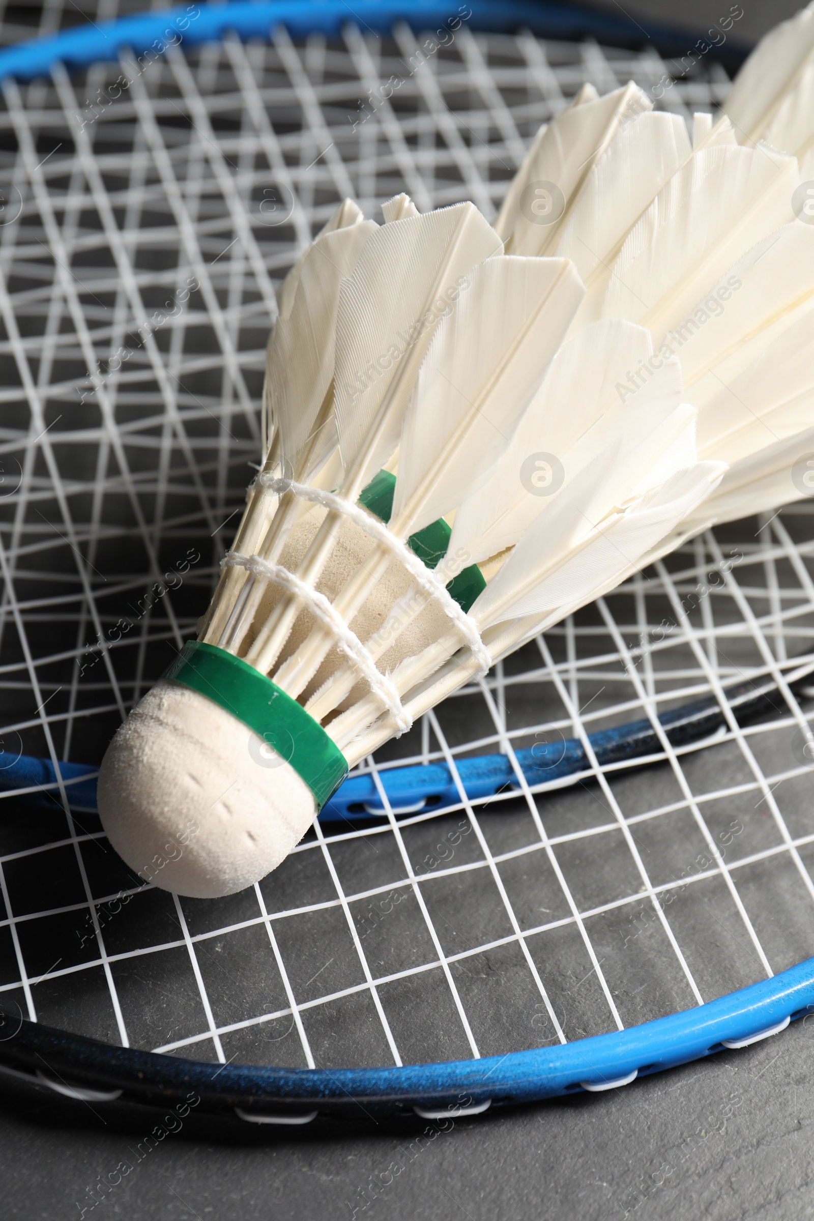 Photo of Feather badminton shuttlecocks and rackets on grey background, closeup