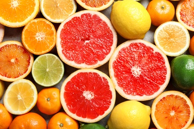 Different citrus fruits as background, top view