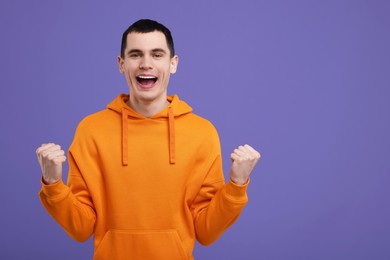 Portrait of surprised man on purple background, space for text