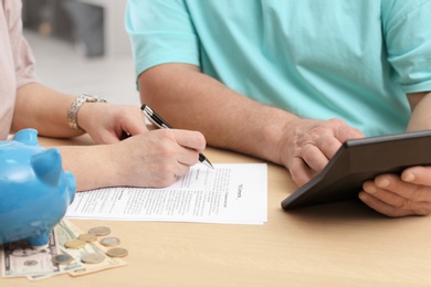 Photo of Mature couple thinking over pension payment at home, closeup