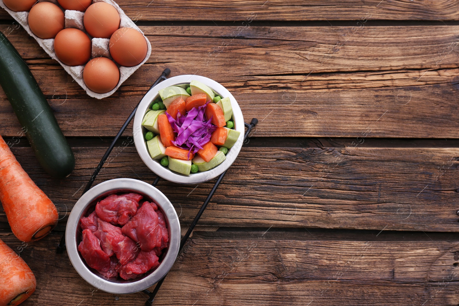 Photo of Flat lay composition with healthy dog food on wooden background. Space for text