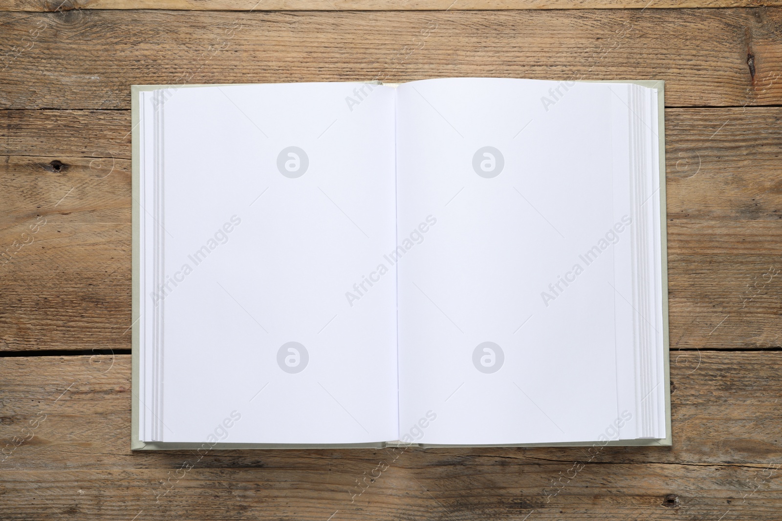 Photo of Open book on wooden table, top view